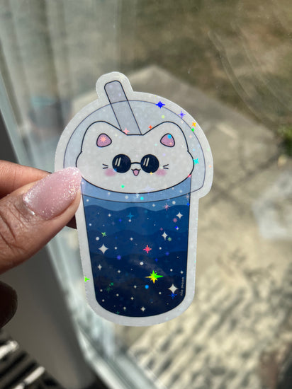 cat boba gleaming holographic sticker by a window with the sun shining