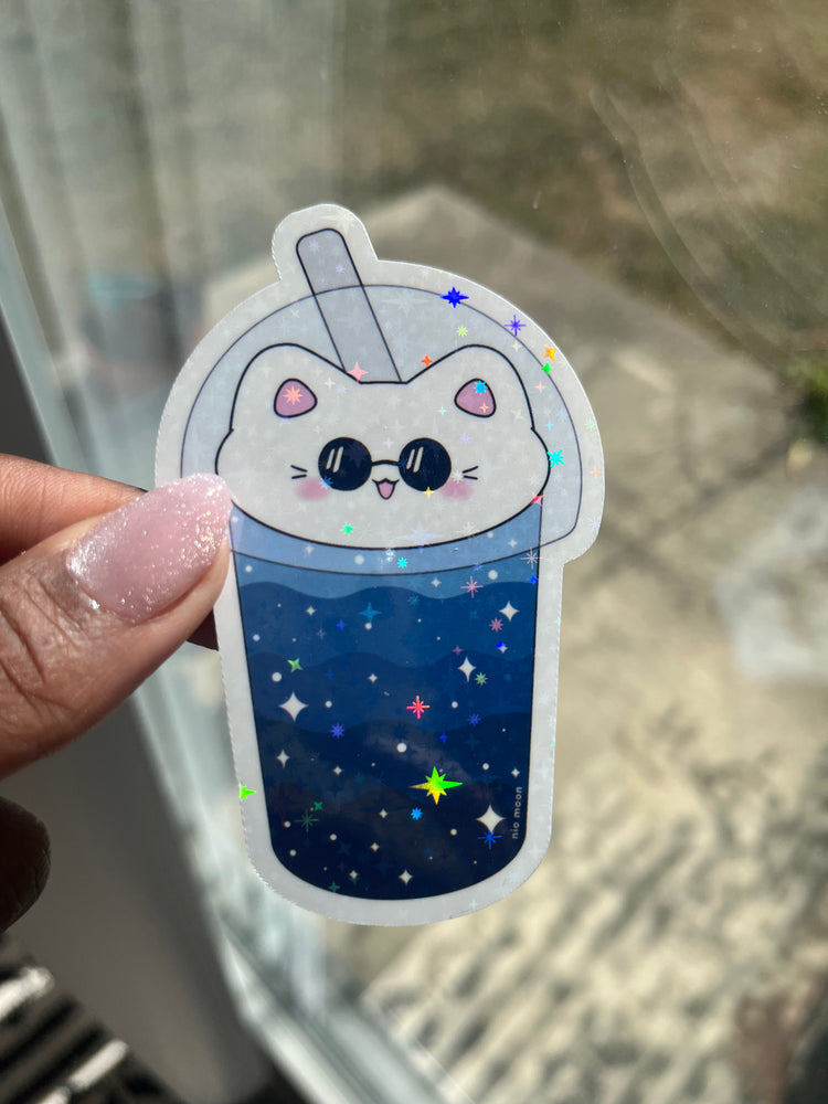 cat boba gleaming holographic sticker by a window with the sun shining